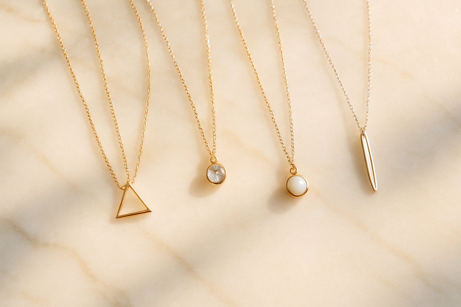  Elegant gold and silver necklaces displayed on beige fabric with soft natural light — minimalist pendants and chains styled for HAVA STORE jewelry collection.